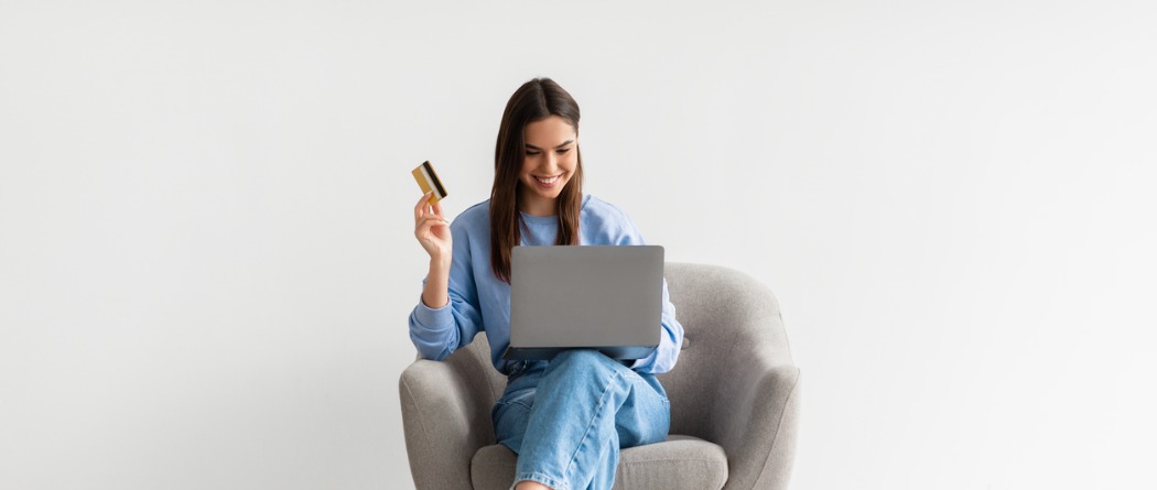 Woman holding a laptop and credit card